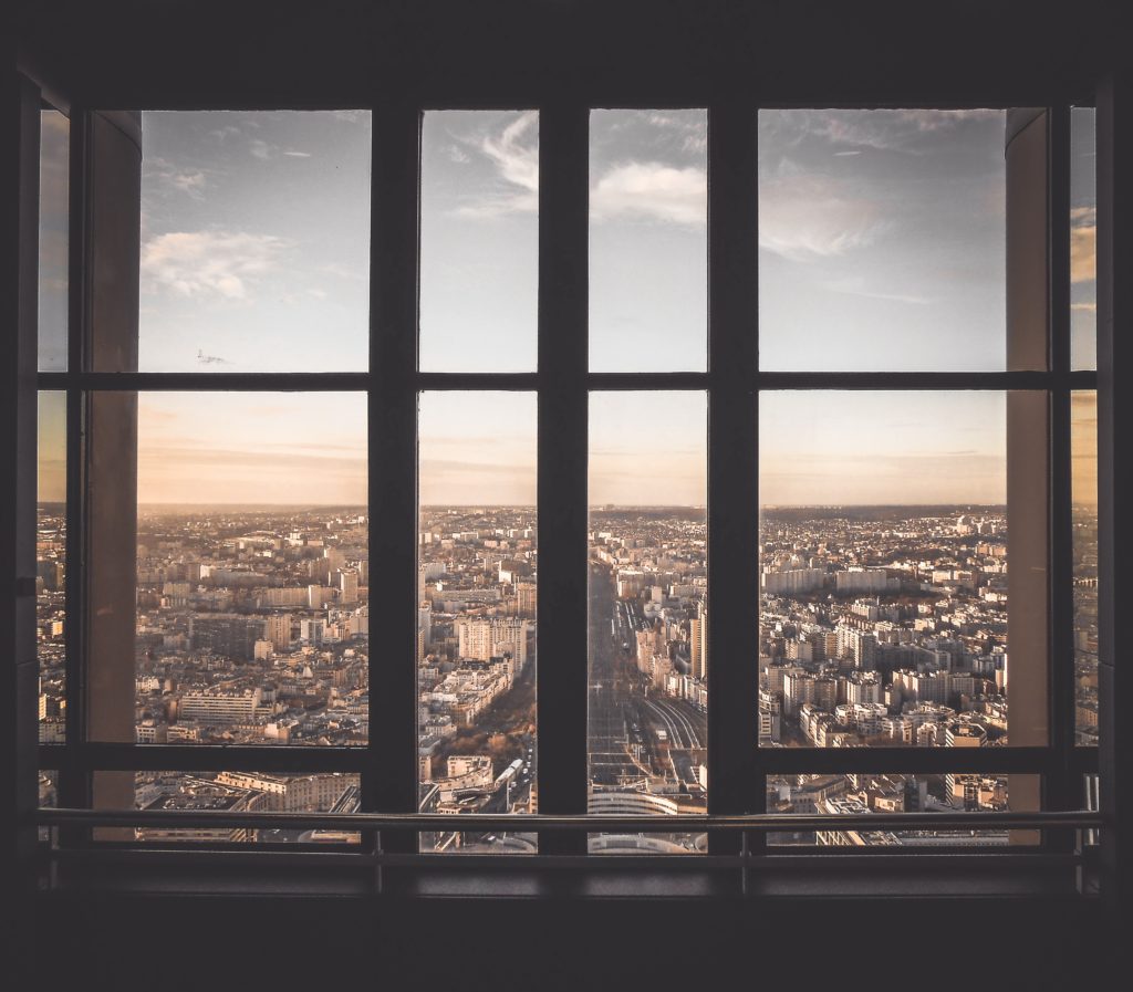 okno na świat za którym widać miasto o poranku